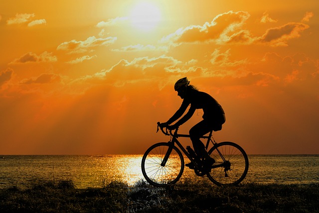 Cyclist fitting a new inner tube into a road bike tire that's partially seated on the rim.