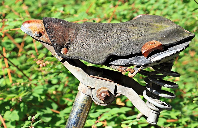 An old worn leather bicycle saddle with springs