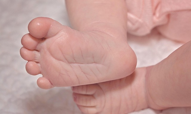 Close-up of a child's feet pushing off the ground on a balance bike.