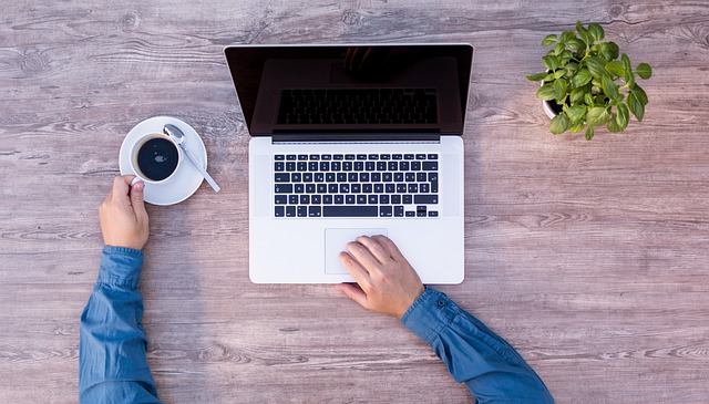 A person working from home, with a cat walking across their keyboard during a video call
