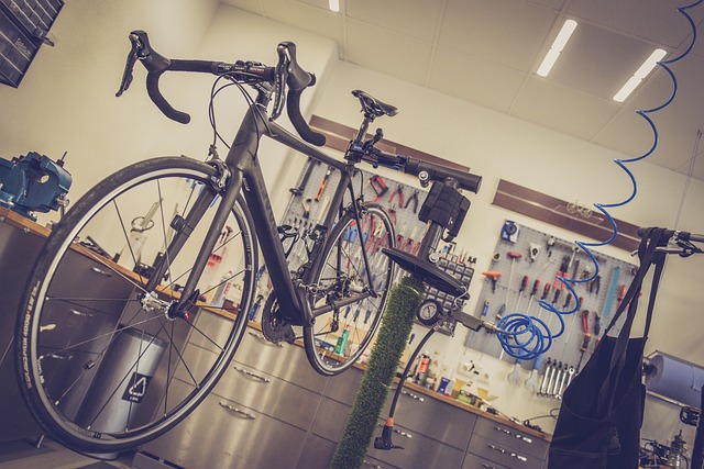A black road bike mounted on a stand in a workshop