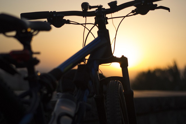 Silhouette of a bicycle outdoors against a sunset sky