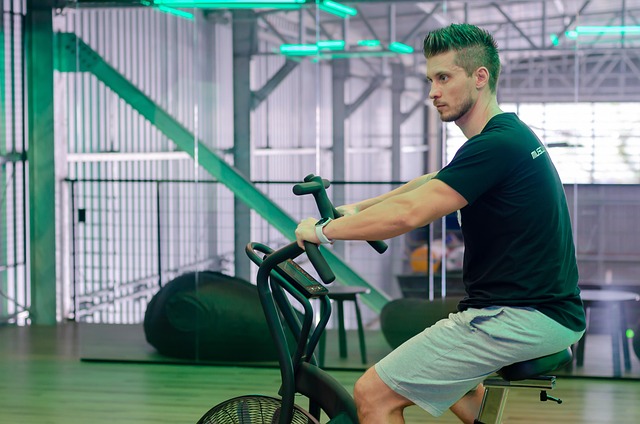 A man riding a stationary exercise bike inside a gym